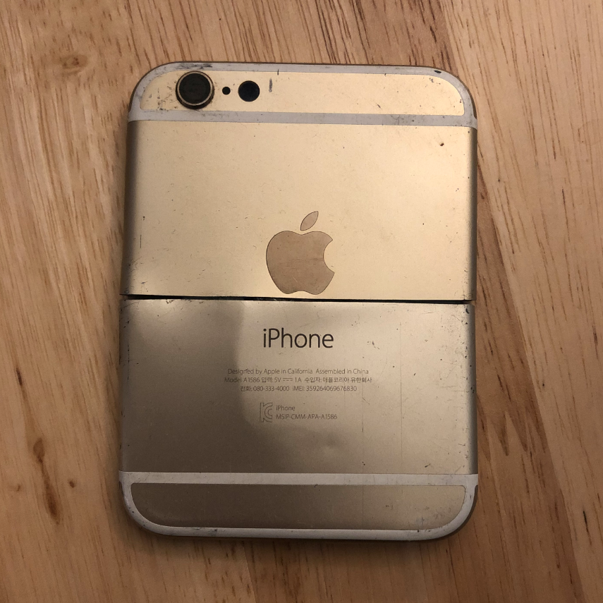 The back of an iphone crudely sawed in half, shortened and positioned back together to make a more square shape