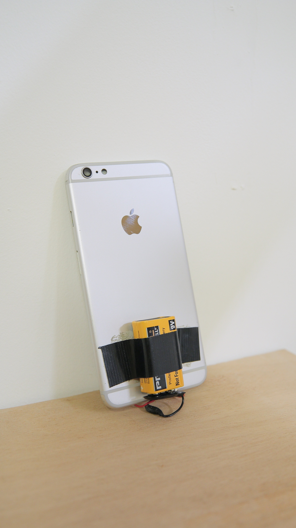Back view of the iphone showing a battery taped to the back